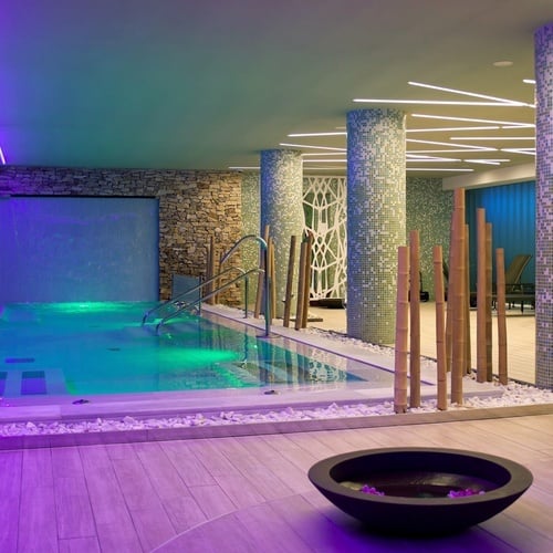 una piscina dentro de un spa con luces moradas
