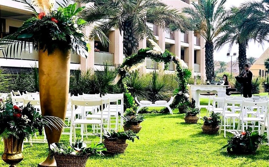 una novia sostiene un ramo de flores mientras se sienta junto a un novio