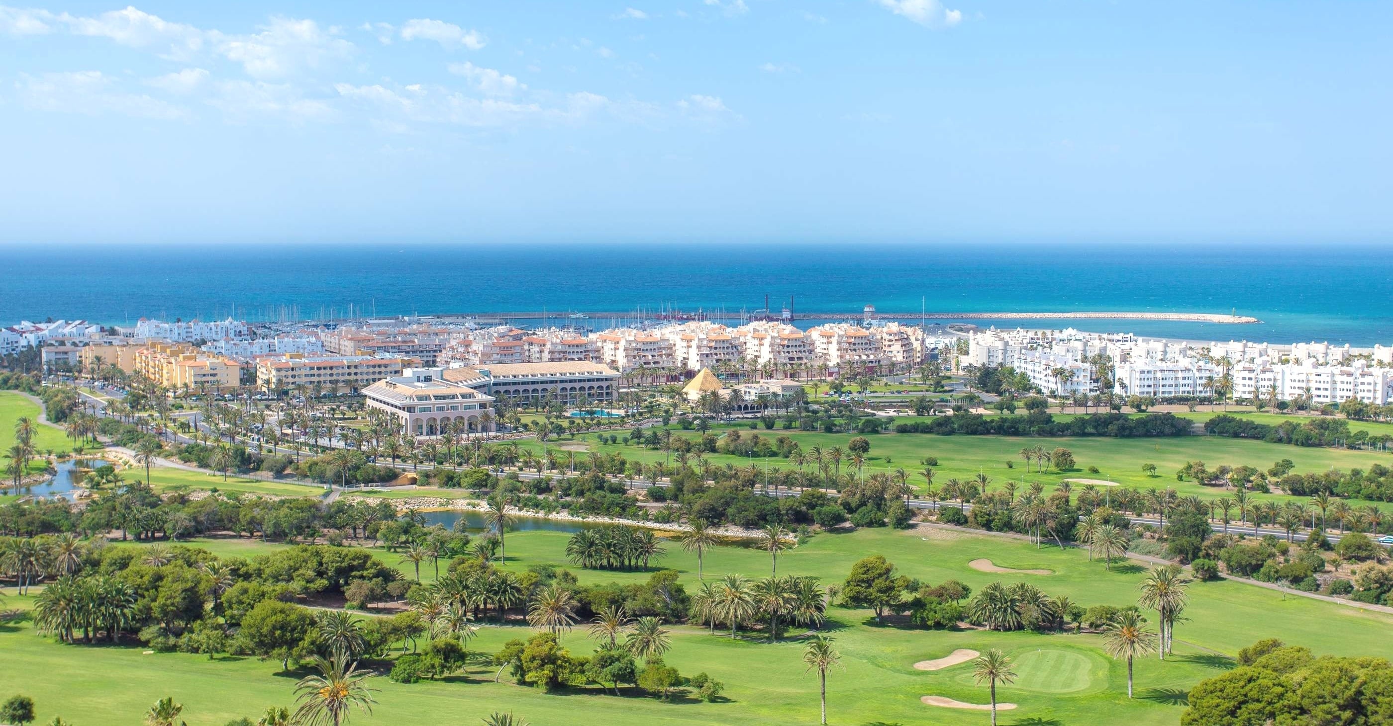 una vista aérea de un campo de golf y una ciudad en el fondo