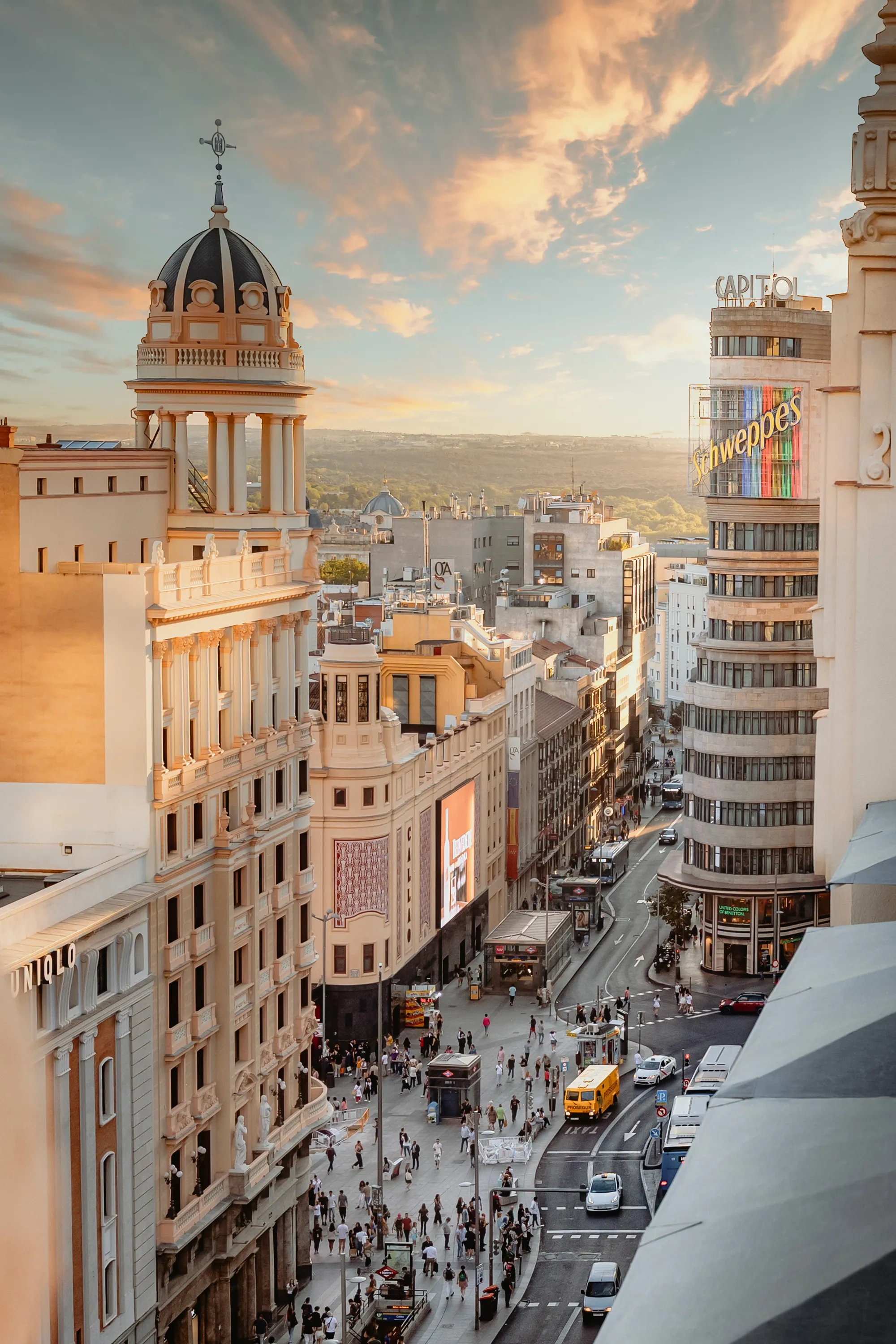 Vista urbana vibrante al atardecer con edificios históricos. Explora Madrid y destinos como AR: Parquesur.