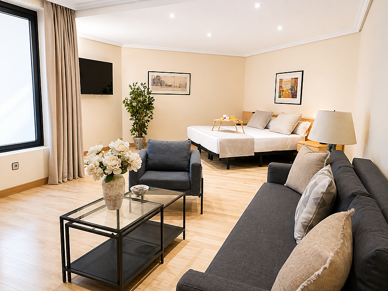 Amplio estudio de hotel con sala de estar, cama y bandeja de desayuno. Apartamentos Parquesur.