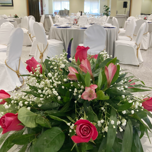 a bouquet of pink roses and baby 's breath sits on a table