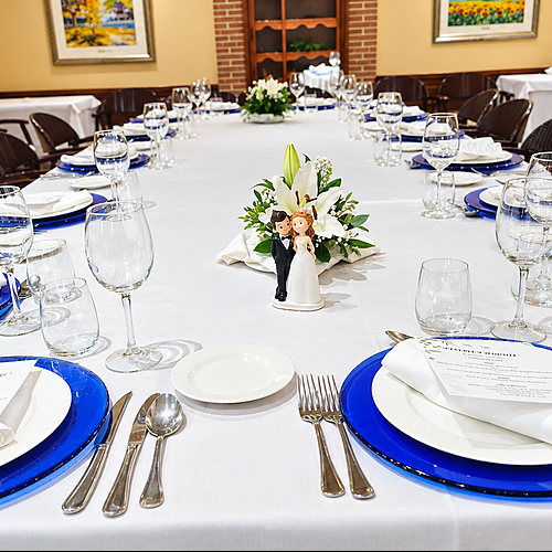 Elegant dining table set for a wedding reception with a AR: Parquesur cake topper and floral centerpiece.