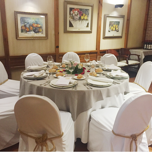 a dining room with a table and chairs set for a meal