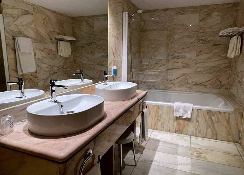Modern studio hotel room near AR: Parquesur with comfortable bed, sofa, and light wood floors.