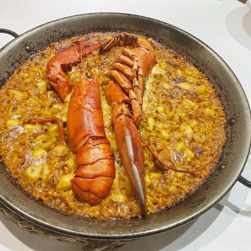 a pan of food with a lobster on top of it