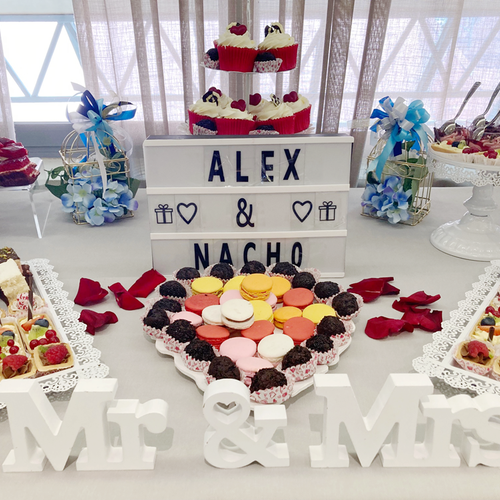 a dessert table with a sign that says alex & nacho