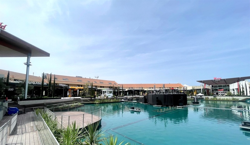 Parquesur outdoor mall with scenic lake and event stage.
