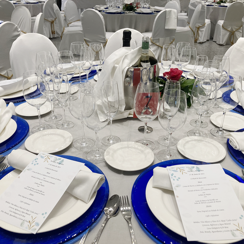 una mesa con platos azules y un menú encima
