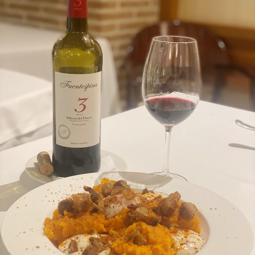 a bottle of fuentespina 3 sits on a table next to a plate of food