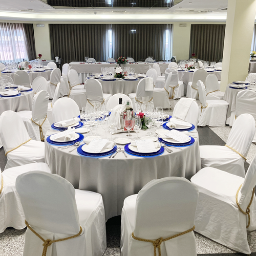 una habitación llena de mesas y sillas preparadas para una boda