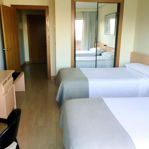 a hotel room with two beds and a desk