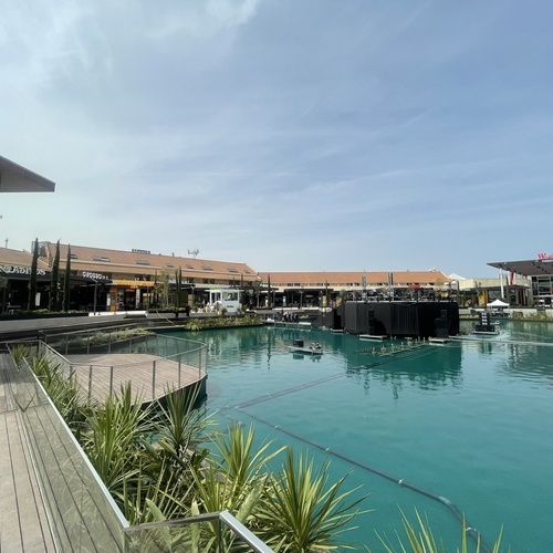 Westfield Parquesur: complejo de ocio exterior con lago, tiendas y restaurantes bajo el sol.