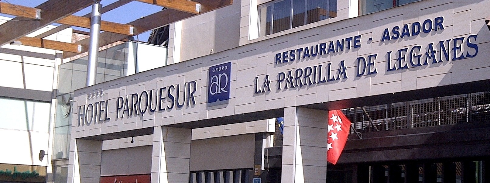 La imagen muestra la fachada del Hotel Parquesur, que también alberga el restaurante-asador La Parrilla de Leganes.