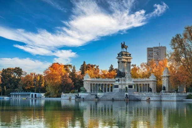 una vista de la ciudad de madrid al atardecer con un gran edificio en el fondo .