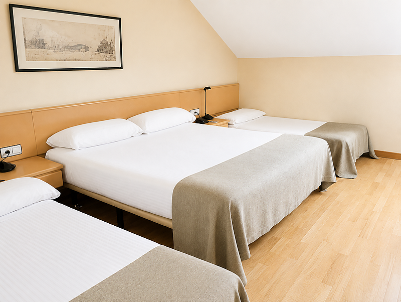 Amplia habitación de hotel con cama doble y dos individuales, ideal para familias que visitan Parquesur.