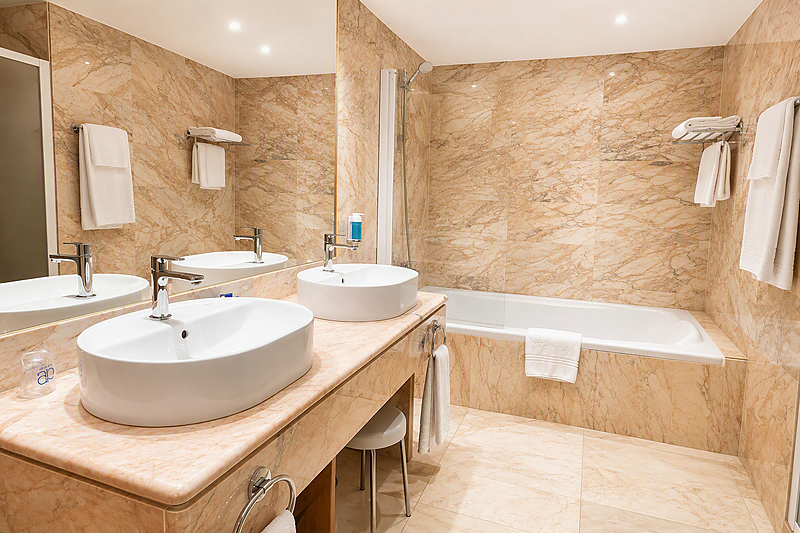 Modern studio hotel room near AR: Parquesur with comfortable bed, sofa, and light wood floors.