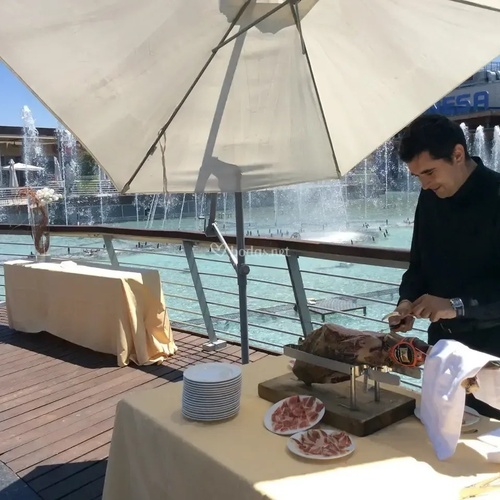 a man cutting a piece of meat in front of a sign that says vega