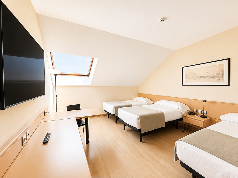 Habitación de hotel con tres camas individuales, claraboya y escritorio, cerca de AR: Parquesur.