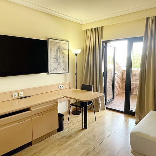 Twin hotel room with two beds, desk, and window, perfect for your stay near AR: Parquesur.