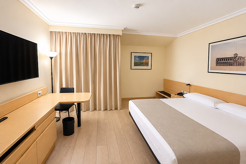 Cómoda habitación de hotel con dos camas individuales, TV y escritorio. Ideal para su estancia cerca de AR: Parquesur.