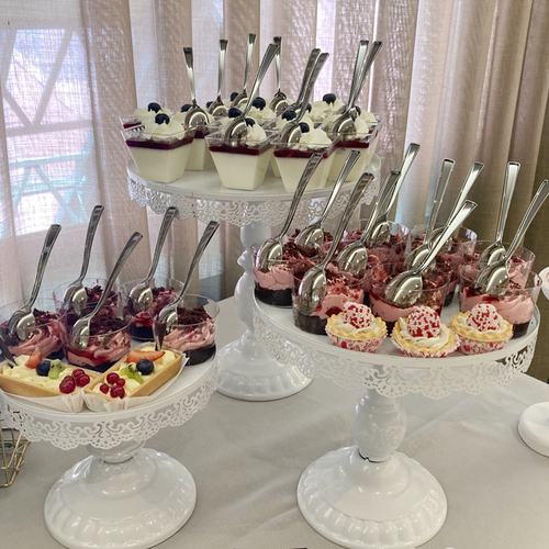 una mesa llena de cupcakes y postres con cucharas