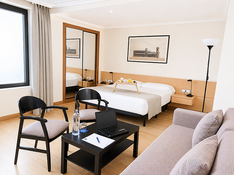 Amplio estudio de hotel con sala de estar, cama y bandeja de desayuno. Apartamentos Parquesur.