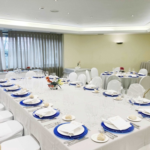 a long white table with blue plates and silverware