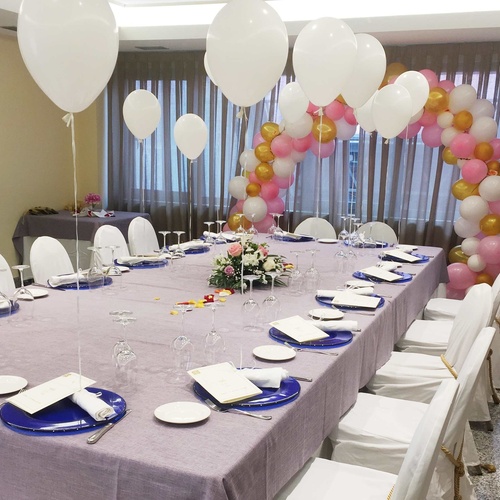 a long table with plates glasses and balloons on it