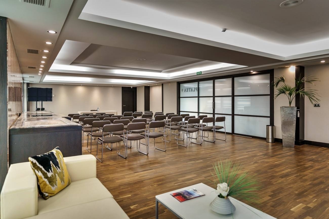 a room with rows of chairs and a sliding glass door that says ' varta ' on it