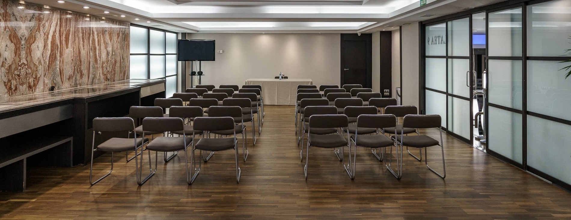 a conference room with rows of chairs and a white table