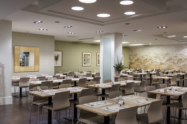 a dining room with tables and chairs and a mirror on the wall