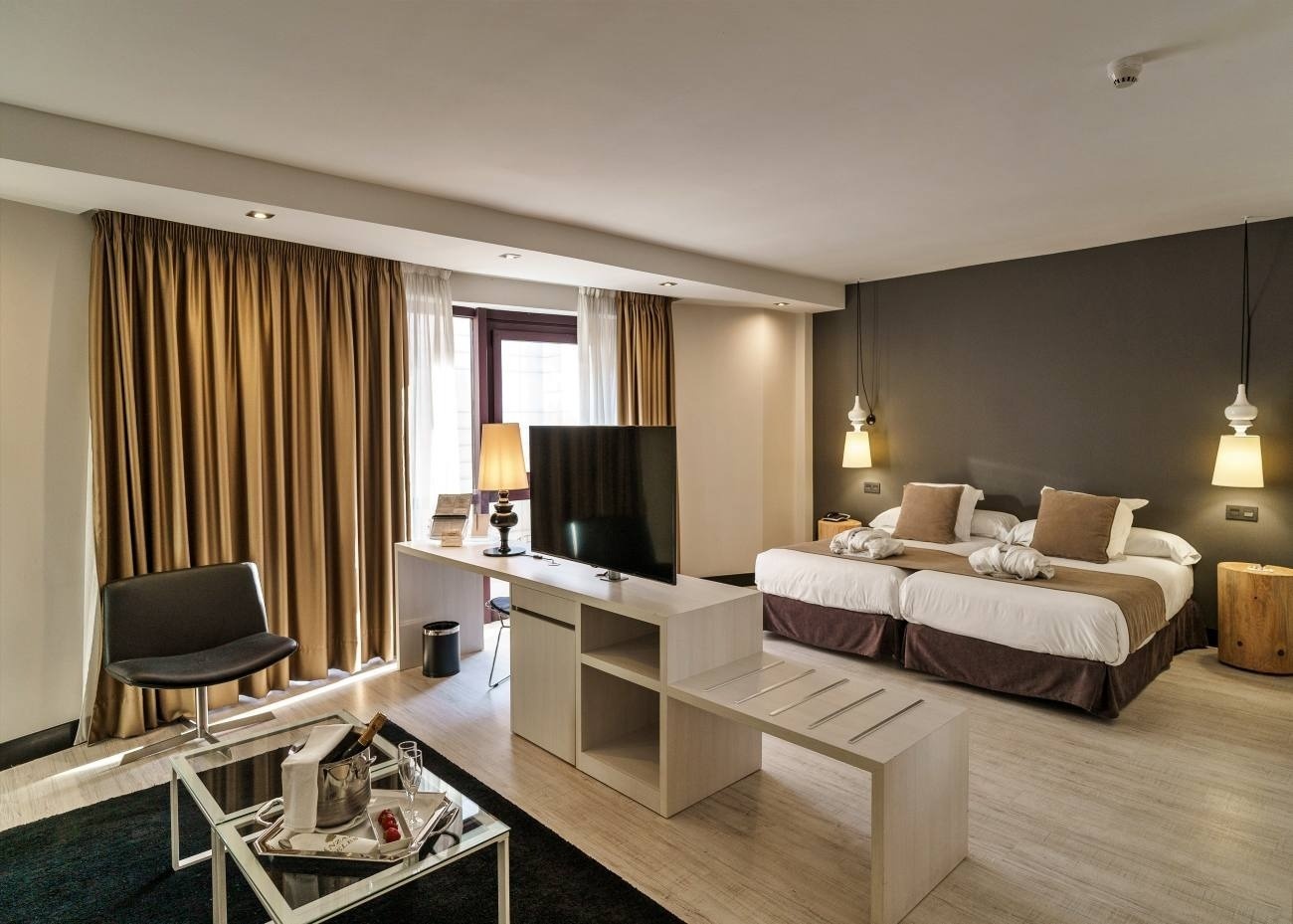 a hotel room with two beds and a flat screen tv