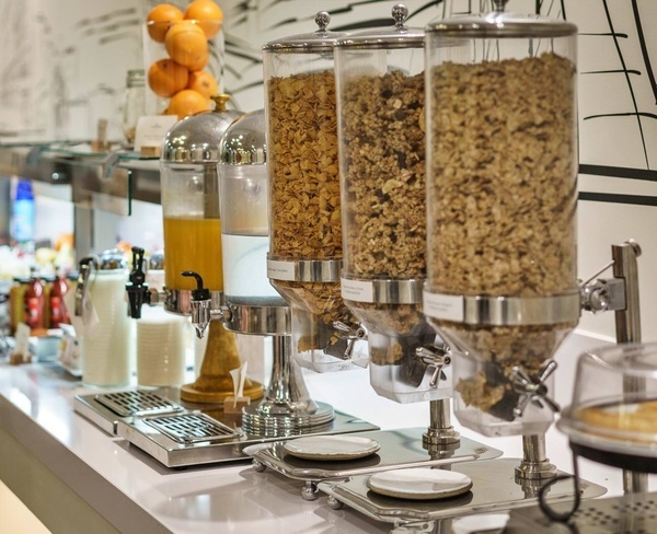 tres dispensadores de cereal y jugo en un restaurante