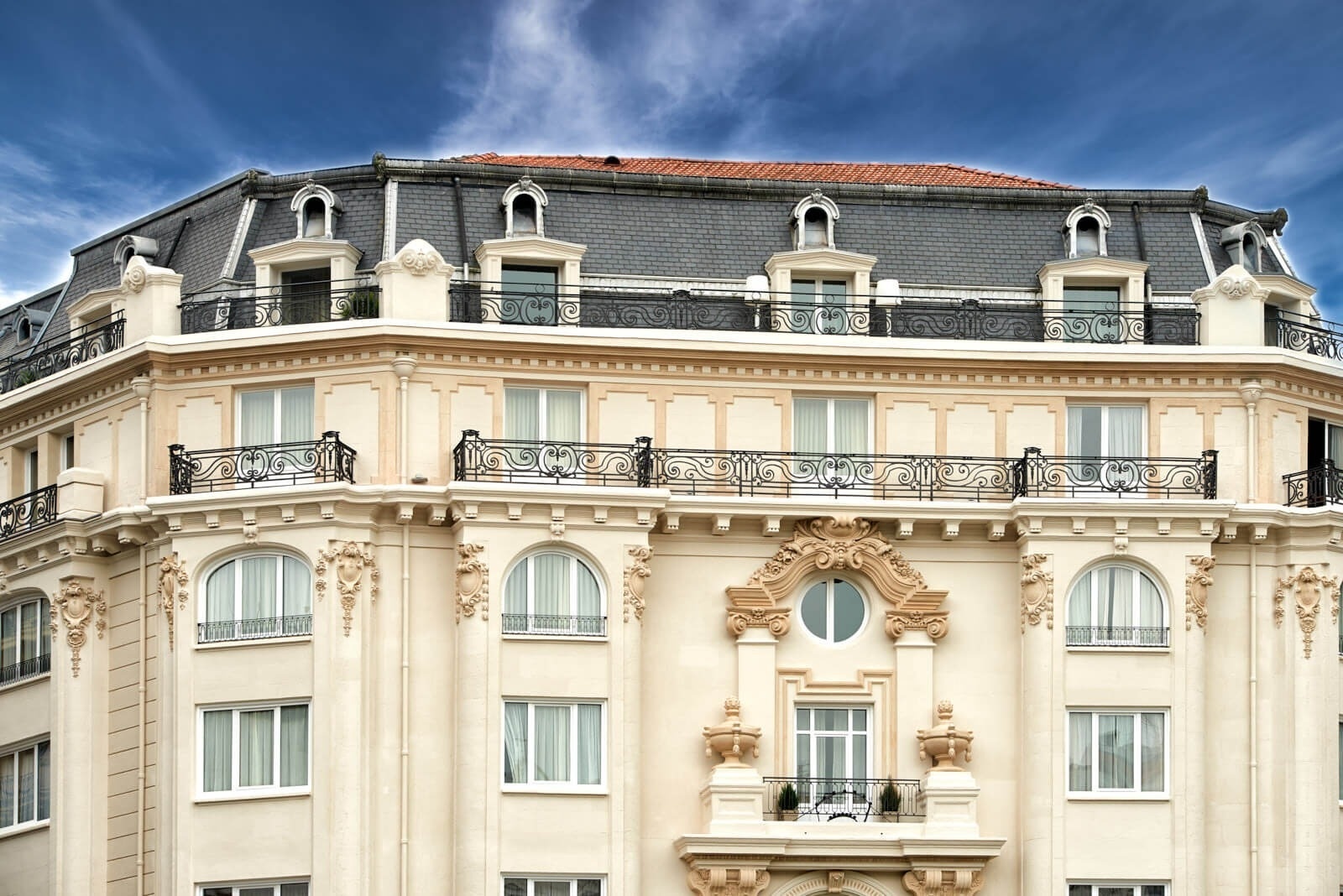 a hotel called hotel carlo sits on the corner of a city street