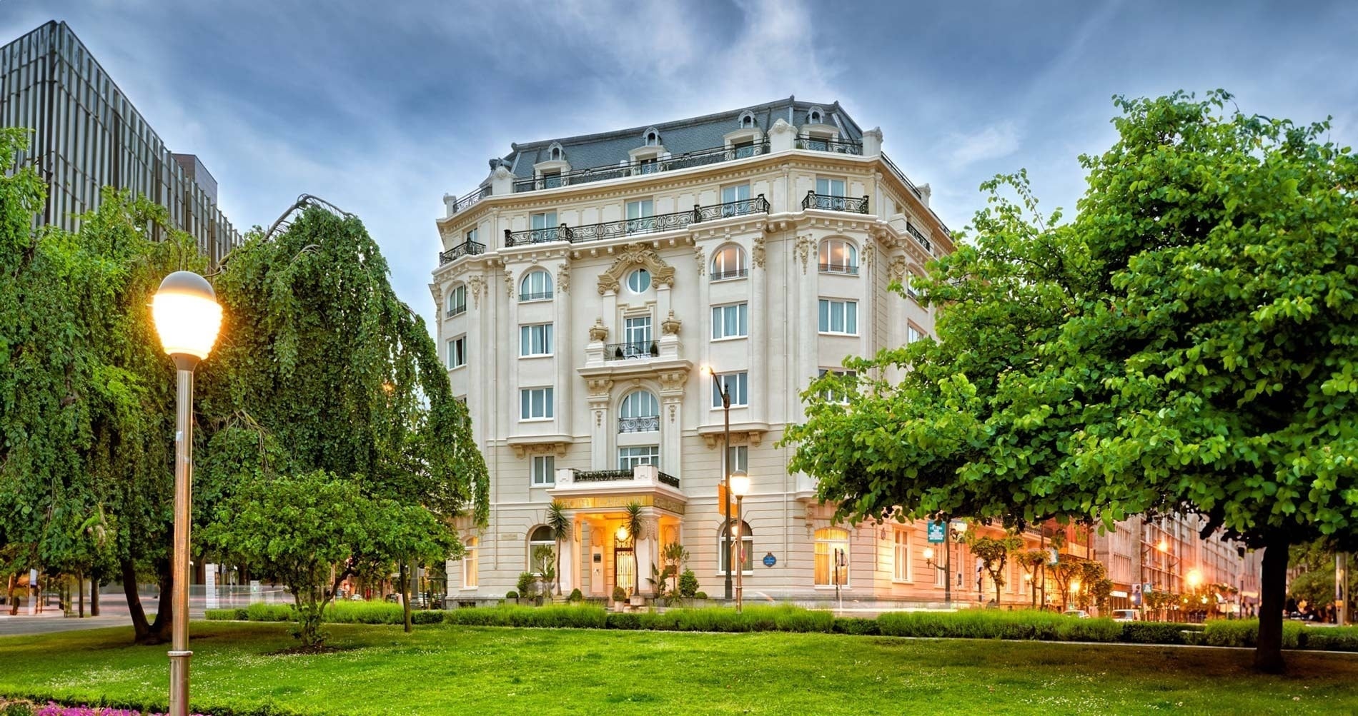la entrada al hotel carlo está rodeada de palmeras