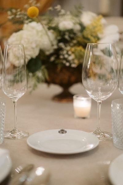 un primer plano de una mesa con copas de vino y un plato