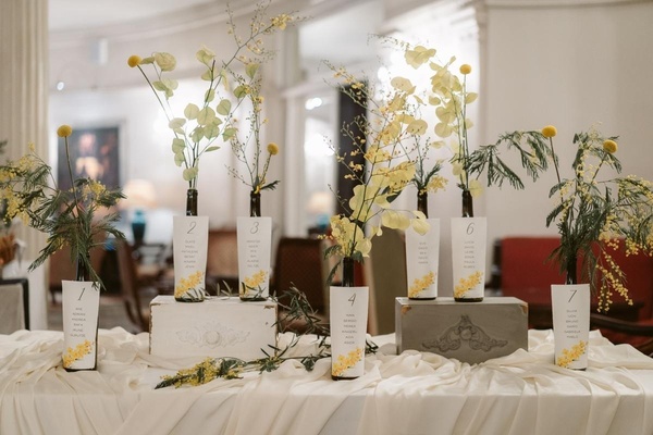 una mesa decorada con botellas de vino y flores amarillas