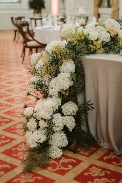 una mesa decorada con flores blancas y verdes