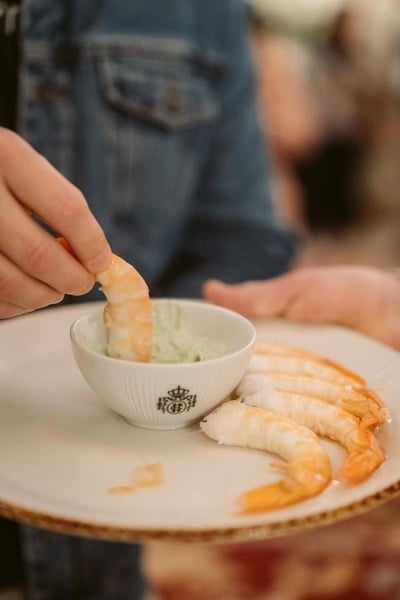 un plato de camarones y un tazón de salsa verde