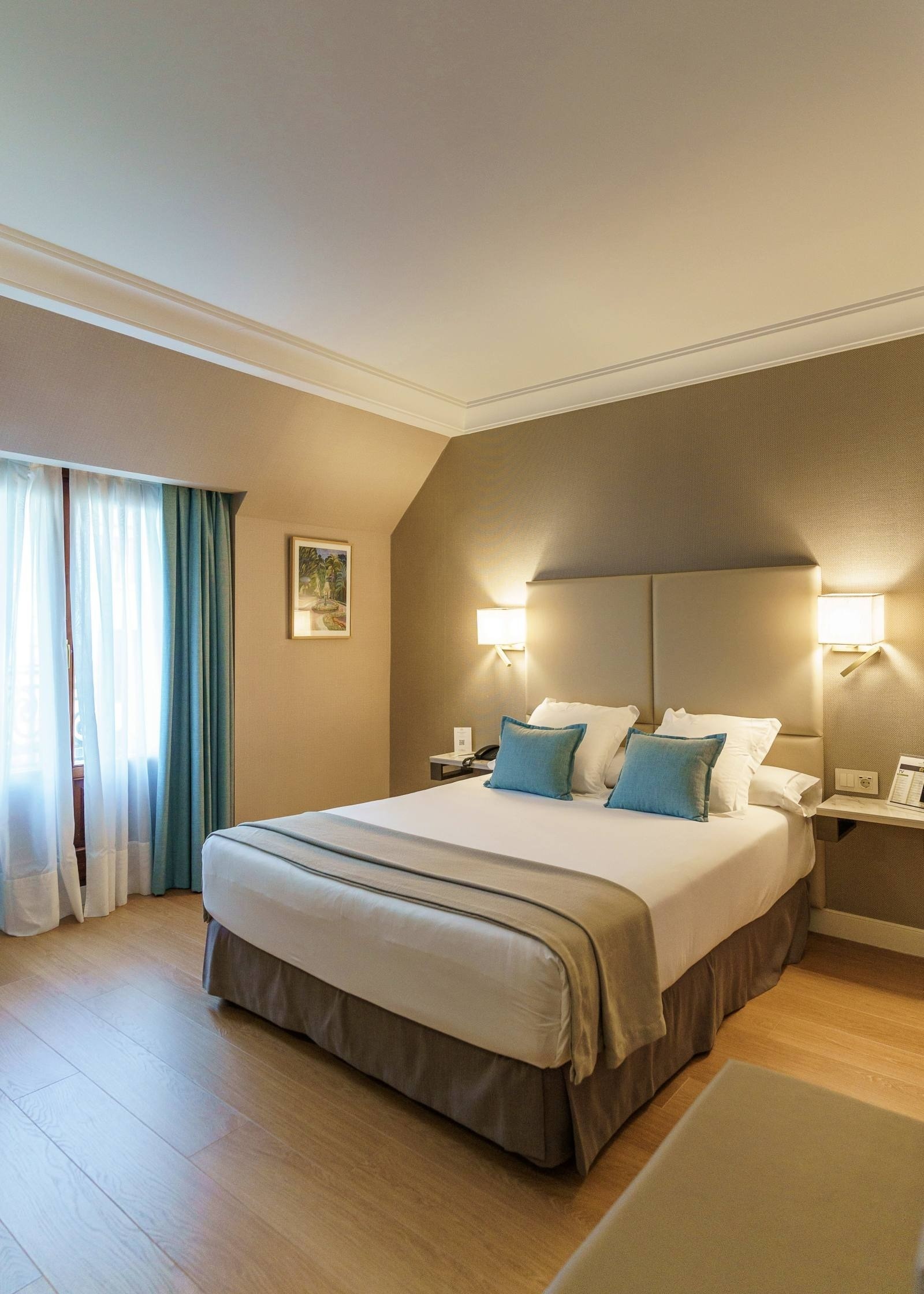 a hotel room with a large bed and blue pillows