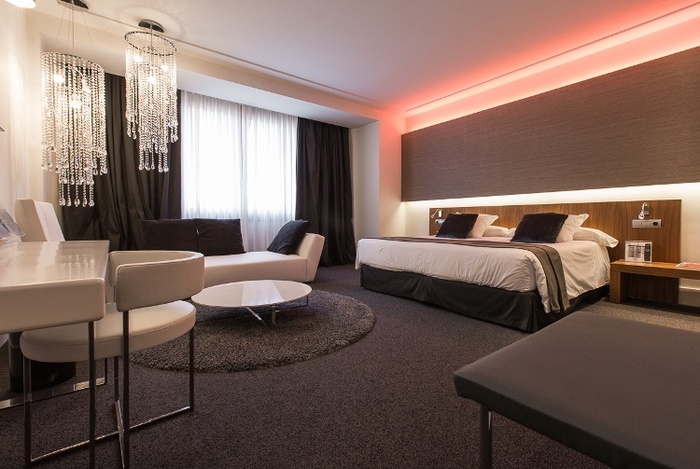 una habitación de hotel con cama , sofá , mesa y sillas .