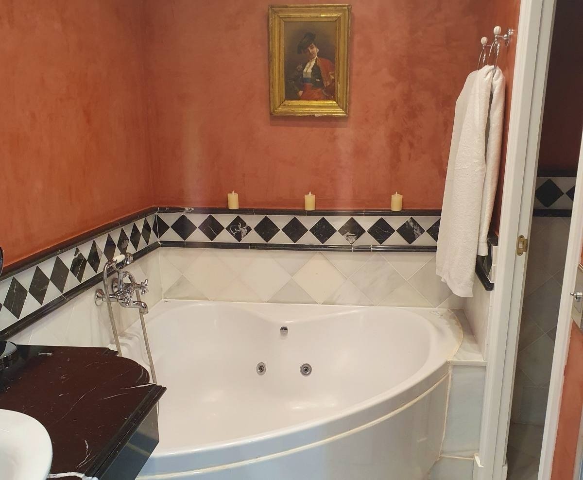 a bathroom with a jacuzzi tub and a painting on the wall above it