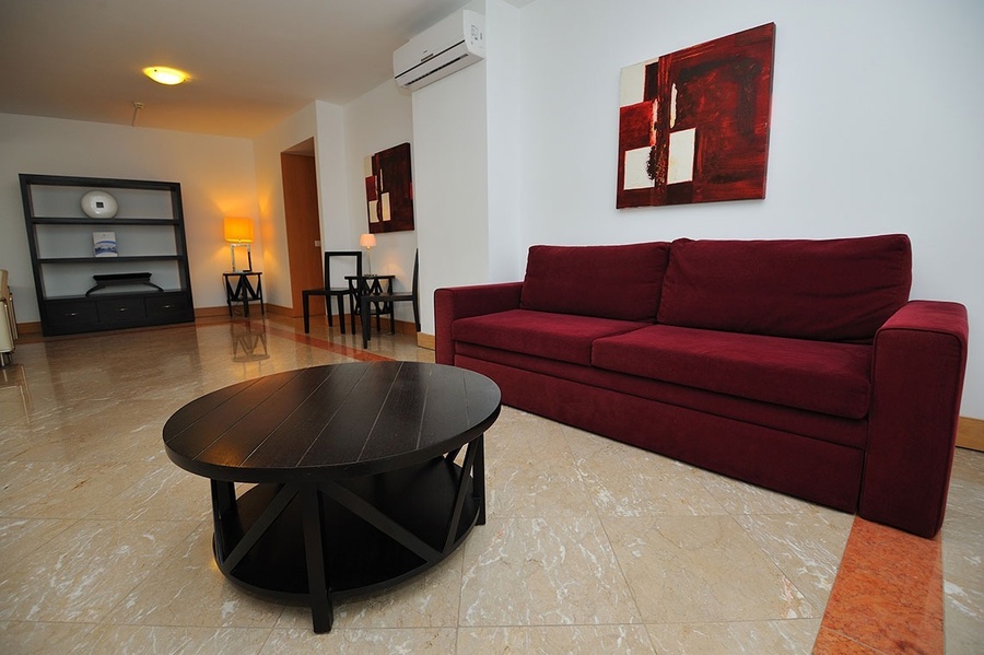 una sala de estar con un sofá rojo y una mesa redonda