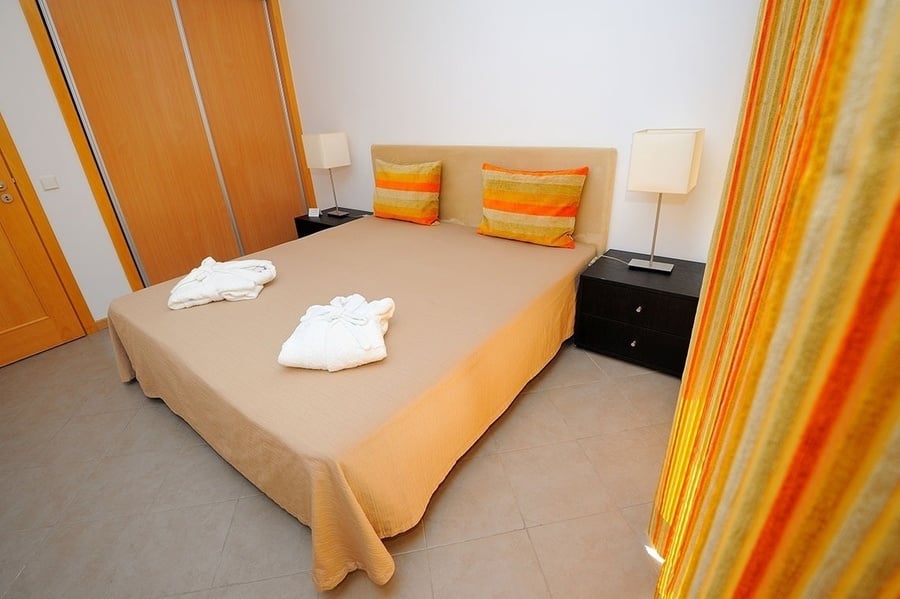 un dormitorio con una cama y dos mesitas de noche