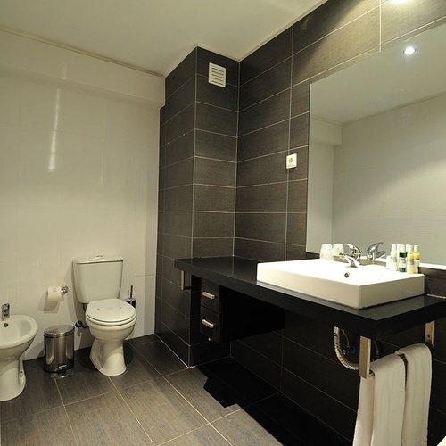 a bathroom with a sink toilet and bidet