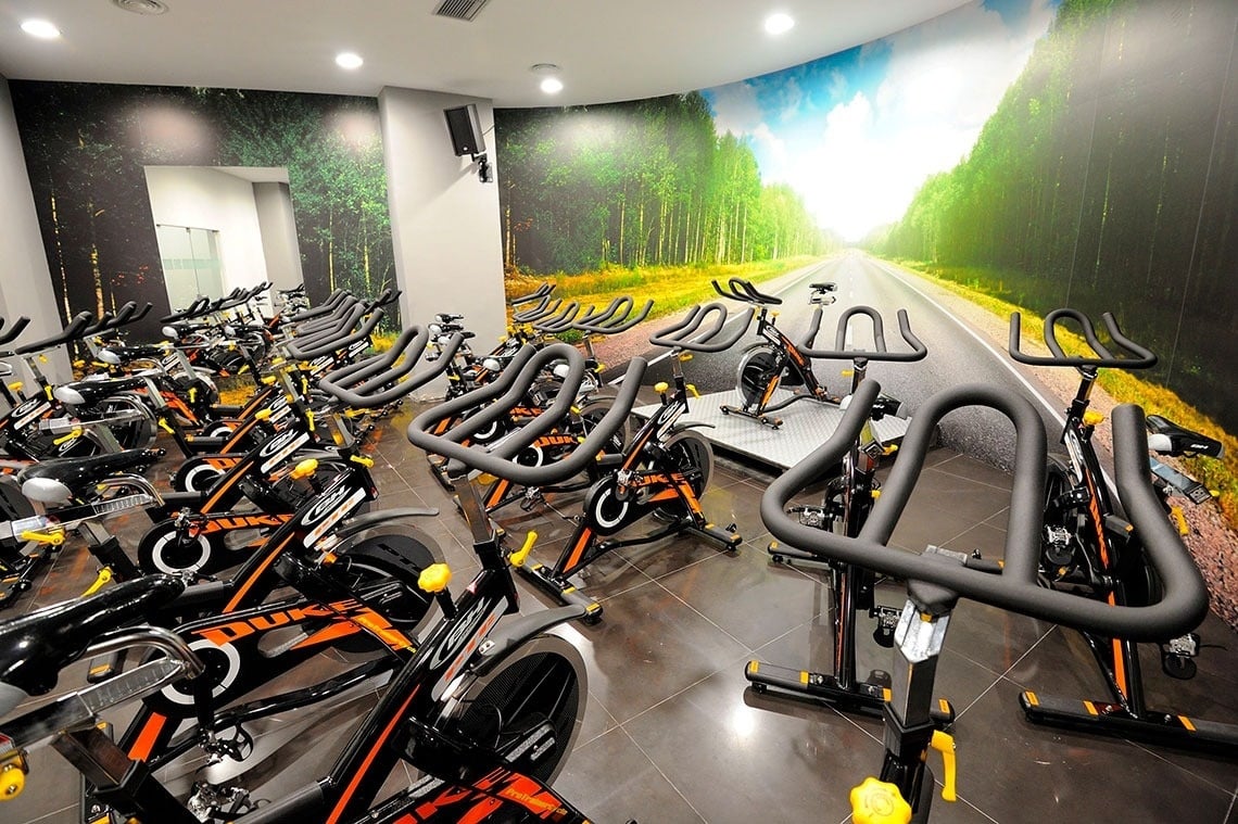 una fila de bicicletas de ejercicio en un gimnasio