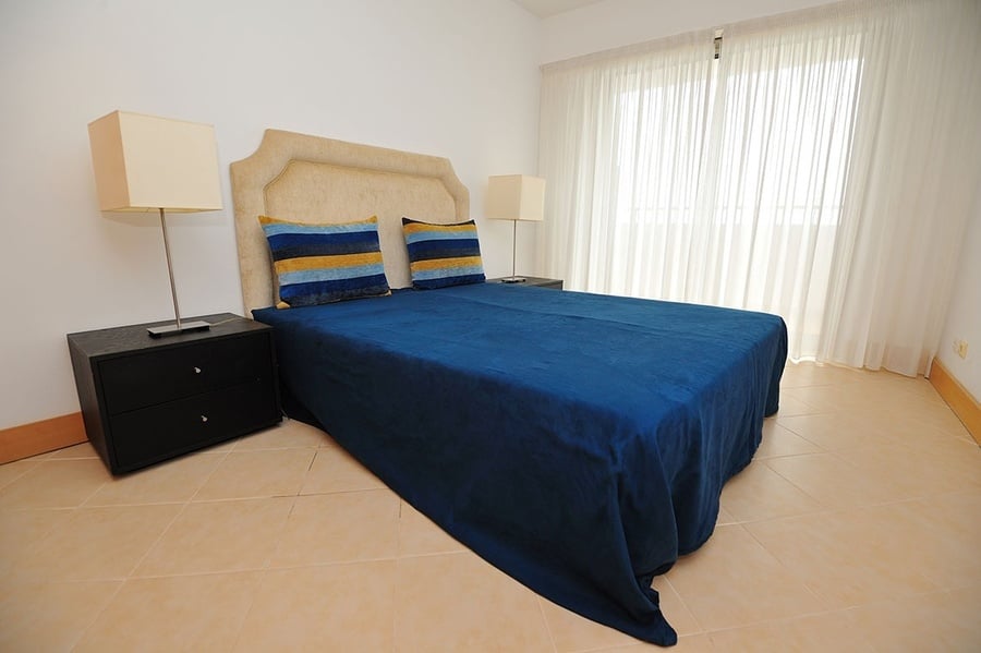 un dormitorio con una cama y dos mesitas de noche