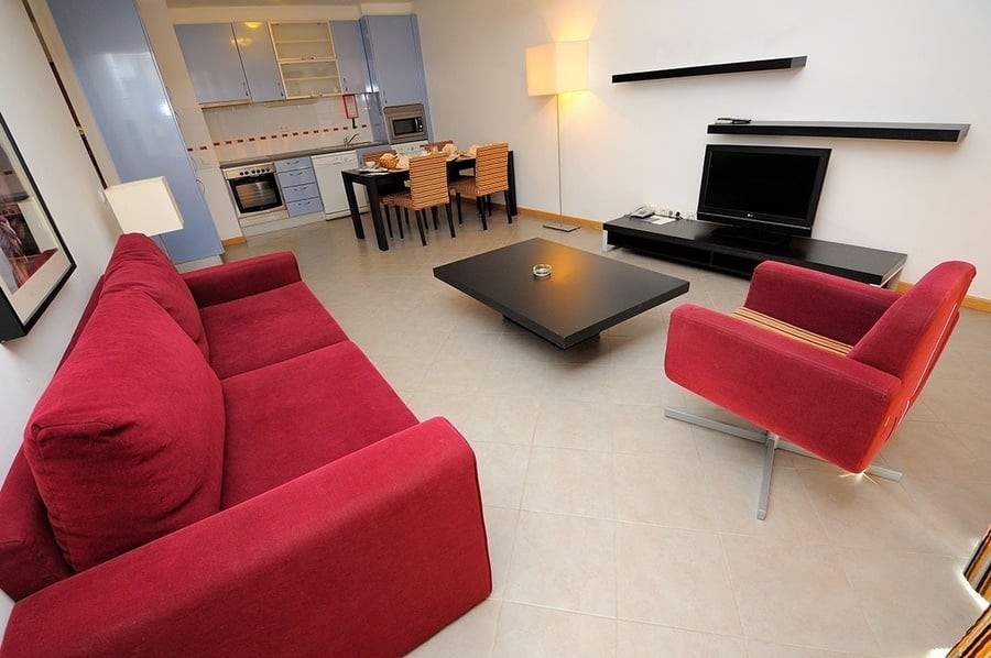 una sala de estar con un sofá rojo y una silla roja
