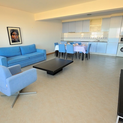 a living room with a blue couch and a picture of a woman on the wall